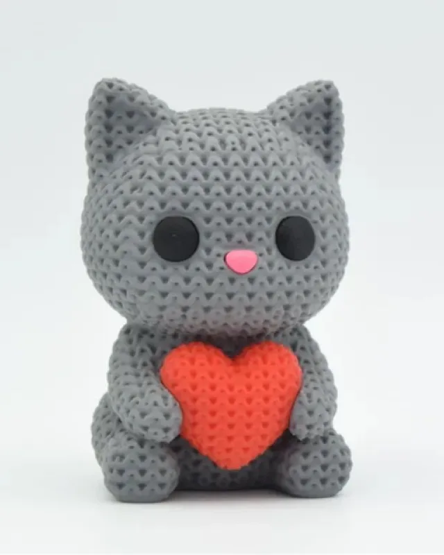 Chat gris imprimé en 3D à la texture tricot, tenant un cœur orange